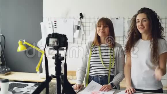 年轻迷人的vloggers服装设计师正在为他们的vlog录制视频女人展示服装素描视频的预览图