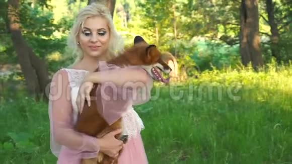 年轻的女人把她最好的朋友狐狸的宠物小狗抱在怀里对狐狸的爱视频的预览图