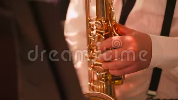 音乐家正在演奏萨克斯管手指上的特写按下仪器的键视频的预览图