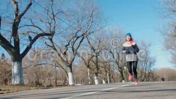 苗条适合年轻妇女跑步或慢跑通过相机户外低角度视角视频的预览图