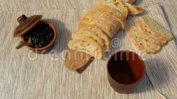 美味的早餐新鲜面包加果酱和牛奶牛奶倒入杯子里用水果果酱在餐巾纸上烤面包均衡食物视频的预览图
