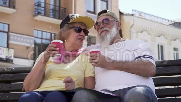 时尚老人喝咖啡和在城市的长凳上放松的肖像视频的预览图