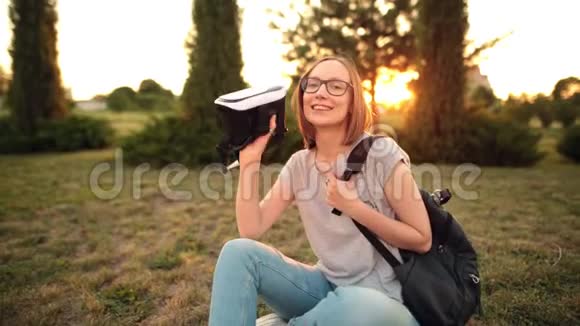 选择性关注虚拟现实眼镜在一个年轻微笑的女孩手中视频的预览图