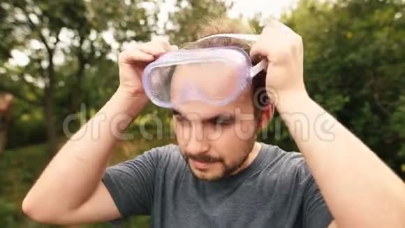 年轻割草机戴透明眼镜保护和隔离耳机视频的预览图