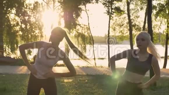 两位年轻女性在公园锻炼减肥健身模特镜头耀斑和美丽的景色背景视频的预览图