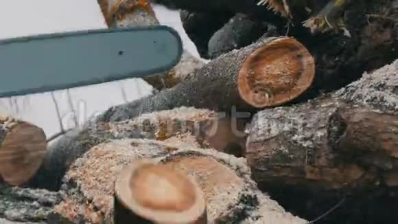 冬天伐木工人用电锯锯柴视频的预览图