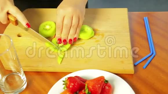 女人用一把刀在木板上切熟的猕猴桃视频的预览图