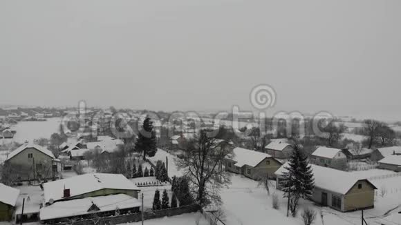 在大雪纷飞的冬日鸟瞰乌克兰村庄平稳向上爬4k视频的预览图