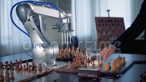 一个人手和一个机械手臂在下棋时移动棋子视频的预览图