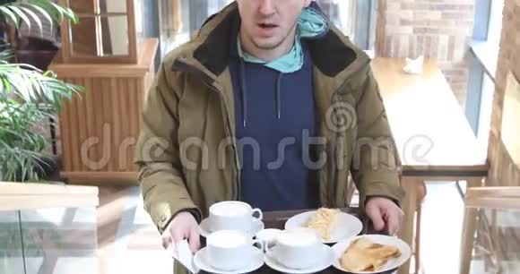 在咖啡馆里男人端着盘子和早餐视频的预览图
