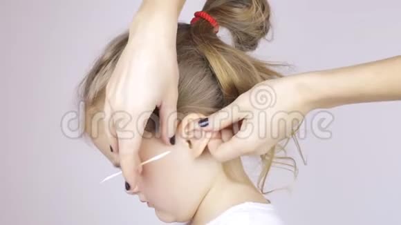 女人用棉签清洁女儿耳朵视频的预览图