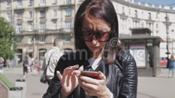 女人在城市街道上的智能手机上搜索信息技术和生活方式理念视频的预览图