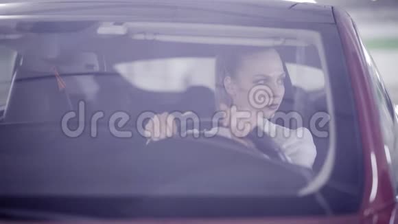一位穿着白色衬衫的漂亮女性在开始吸烟时坐在红色的车后轮视频的预览图