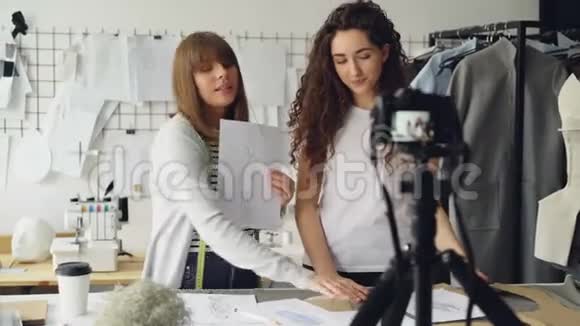年轻漂亮的女性时装设计师博主们正在用相机录制关于缝制新服装的视频女孩视频的预览图