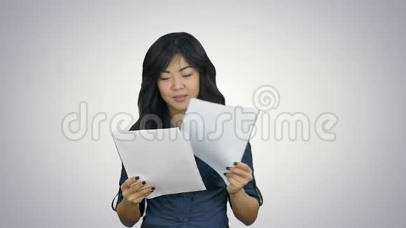 美丽的亚洲女孩笑着把纸扔在白色背景上视频的预览图