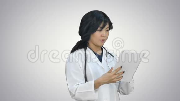 亚洲女医生使用数码平板电脑在白色背景下微笑视频的预览图