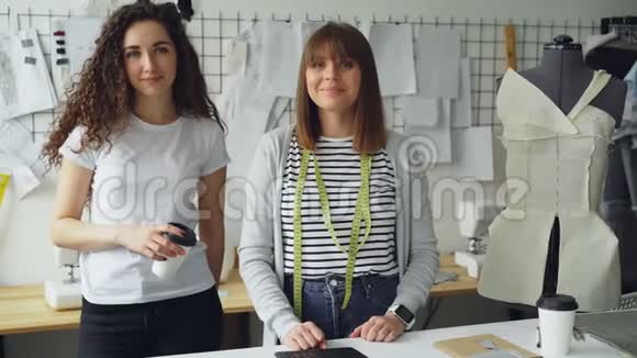 两位女服装设计师企业家站在车间一起看相机的肖像一个女人视频的预览图