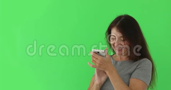 一位老年妇女看着智能手机上的照片视频的预览图