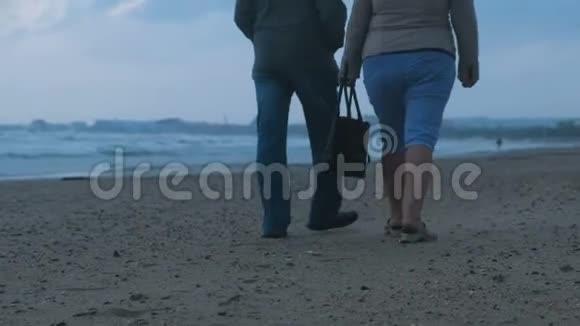 无法辨认的老年夫妇在晚上沿着海边散步后景视频的预览图