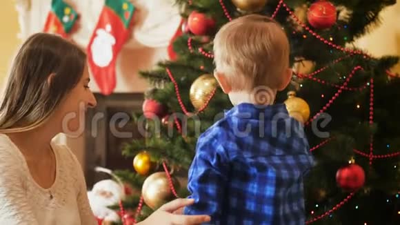 幼儿小男孩用饰品装饰圣诞树的4k视频视频的预览图