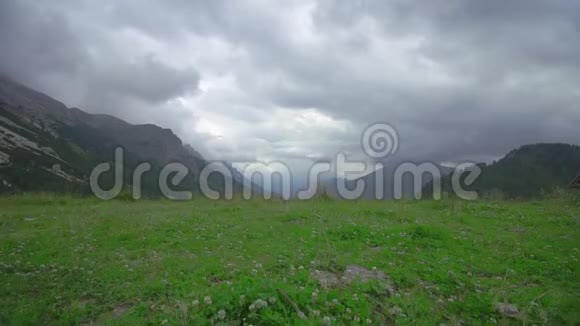 阿尔卑斯山中的群山绿荫覆盖头顶上流着云视频的预览图