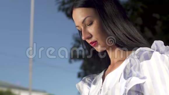 穿着白色衬衫的时髦女人接电话视频的预览图