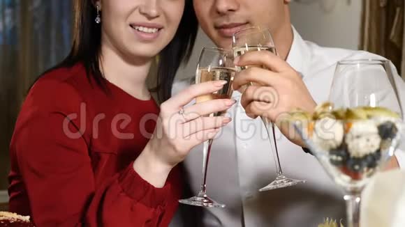 年轻夫妇在餐馆里品尝香槟约会年轻人和女人在餐馆里喝浪漫晚餐视频的预览图