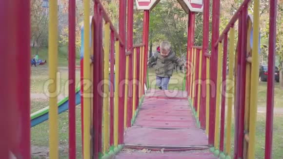 快乐的男孩在操场上的桥上奔跑视频的预览图