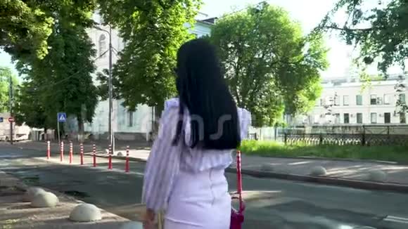 时尚女性留着长发在城市街头打电话视频的预览图