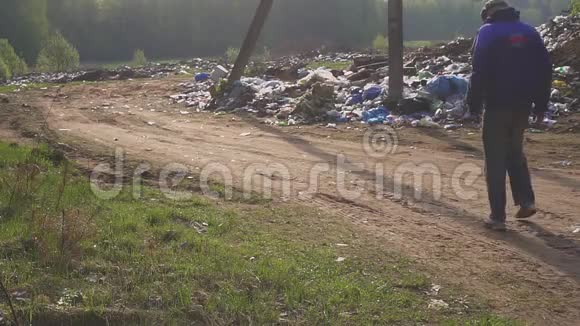 无家可归的人沿着垃圾堆在散步饥饿和贫穷视频的预览图