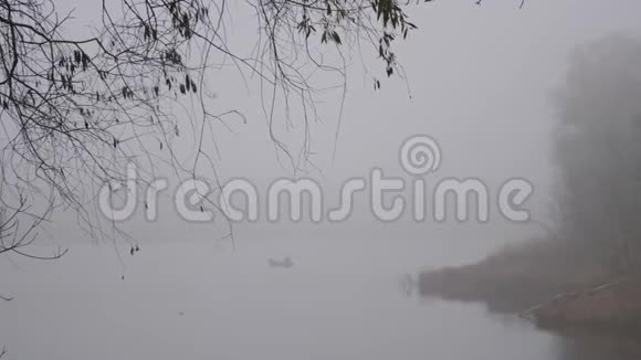 雾天早晨渔民在水上的船上视频的预览图