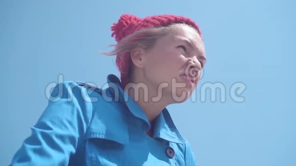 滑稽的女孩站在一件蓝色的外套和红色的帽子里手里拿着一个木棍视频的预览图