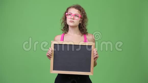 年轻快乐美丽的书呆子女人一边拿着黑板思考视频的预览图