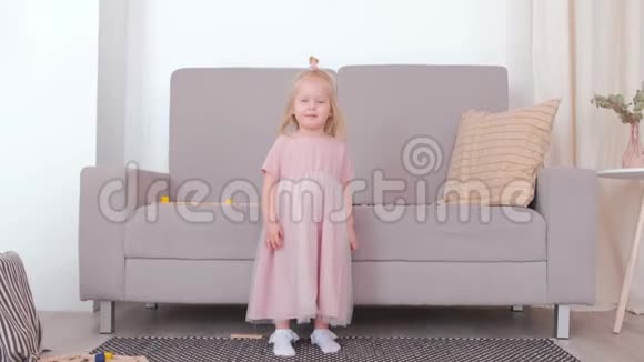 小可爱的快乐女孩穿着漂亮的粉红色连衣裙旋转视频的预览图