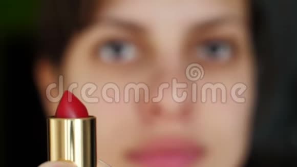 年轻的女人拿着红色的口红视频的预览图