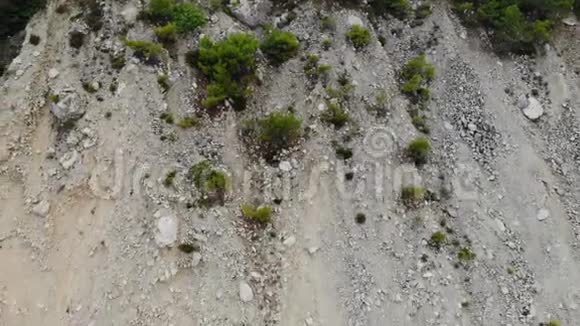 带石头和绿松石海波的悬崖海岸线鸟瞰垂直空中4K视频视频的预览图