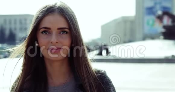 年轻女孩戴着牙套看着摄像机微笑地站在城市里视频的预览图