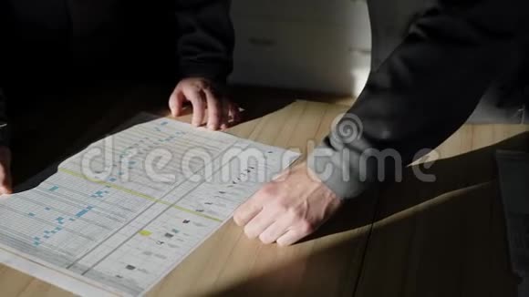 两个工人正在检查一家工厂的生产计划看一张有图形的纸躺在桌子上视频的预览图