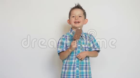 有趣的男孩在白色背景下吃冰淇淋视频的预览图