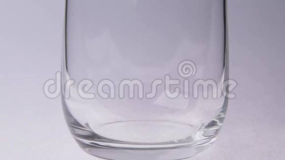 在白色背景上将水倒入玻璃杯中视频的预览图