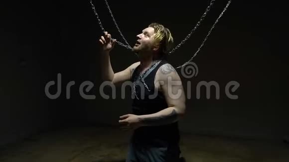 疯狂的金发男人被绑在链子上视频的预览图
