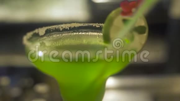酒精鸡尾酒装饰水果站在酒吧柜台上提供绿色和橙色水果鸡尾酒供饮用视频的预览图
