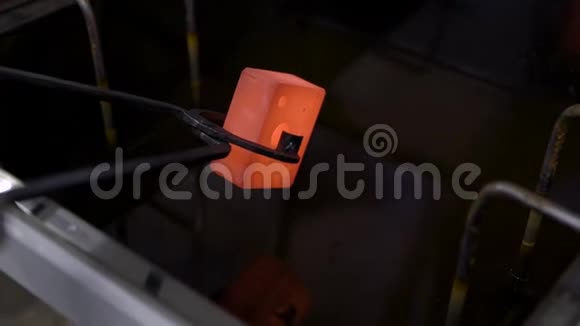 工人用镊子夹住加热的金属细节并将其放入冷水中冷却特写视频的预览图