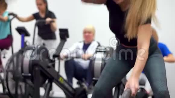 这名妇女正在积极参加带着战斗绳索的健身房锻炼视频的预览图