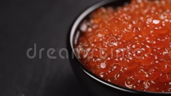 红色鱼子酱在黑色背景上旋转视频的预览图