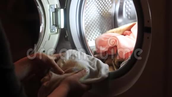 女的把脏衣服递给洗衣机视频的预览图