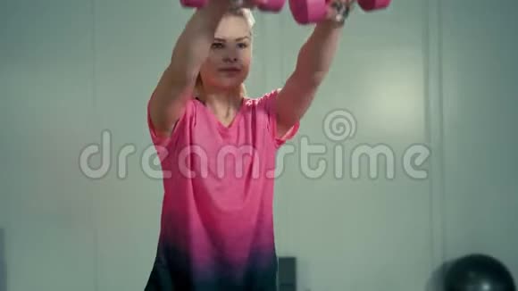 年轻女子正在健身训练中做运动和举重运动视频的预览图