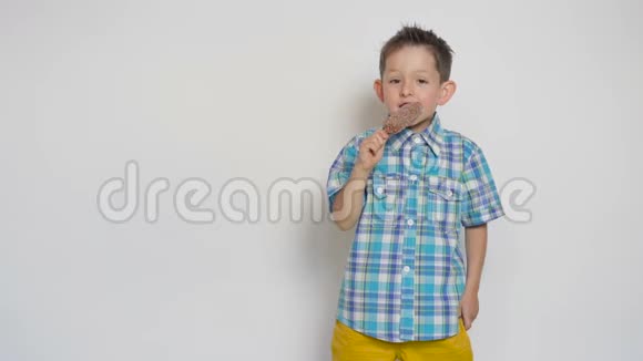 可爱的男孩在白色背景下吃冰淇淋视频的预览图