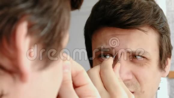 年轻人用镊子夹着眉毛从疼痛中获胜漂亮的眉毛视频的预览图