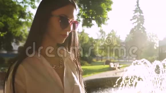 优雅的黑发女郎戴着时髦的太阳镜享受早晨的阳光视频的预览图